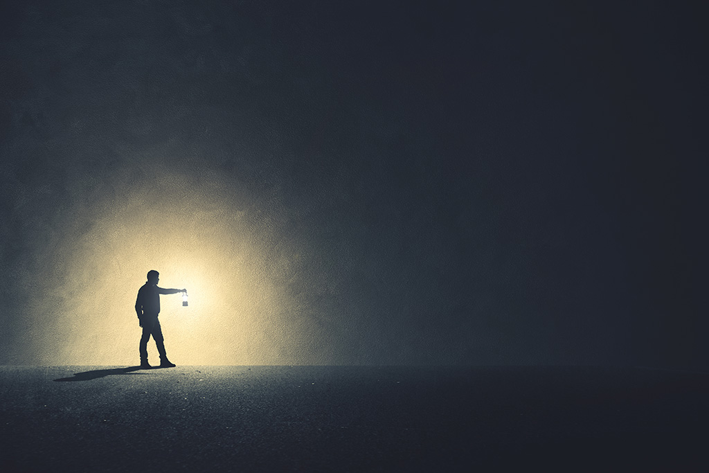مقصد از خلقت انسان چیست؟_مجله رشد 23 مرد کنار دیوار با چراغ در دست در تاریکی
